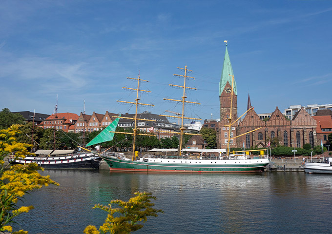 Seitenansicht des Großseglers "Alexander von Humboldt" auf der Weser. Im Hintergrund ist die St. Martini Kirche zu sehen.